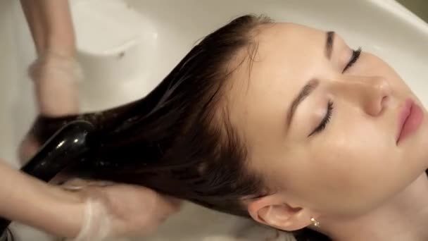 Hair stylist sta lavando i capelli delle giovani donne primo piano — Video Stock
