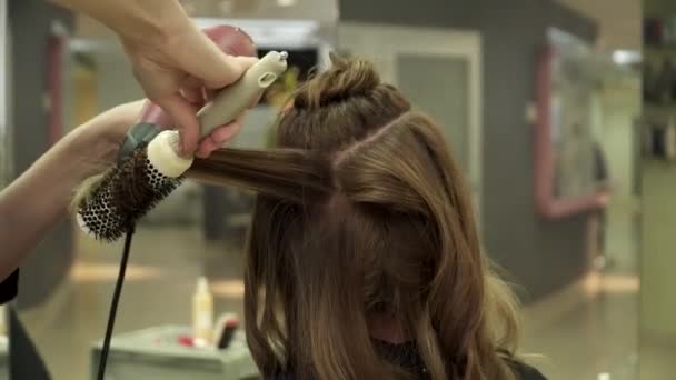 Frisören gör frisyr för en ung kvinna i salong — Stockvideo
