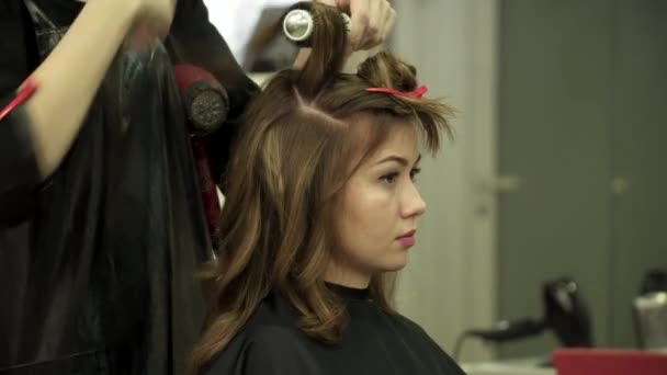 Peluquería está haciendo corte de pelo para una joven hermosa mujer — Vídeos de Stock