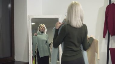 Genç kadın polo boyunları aynanın önünde üzerinde çalışır