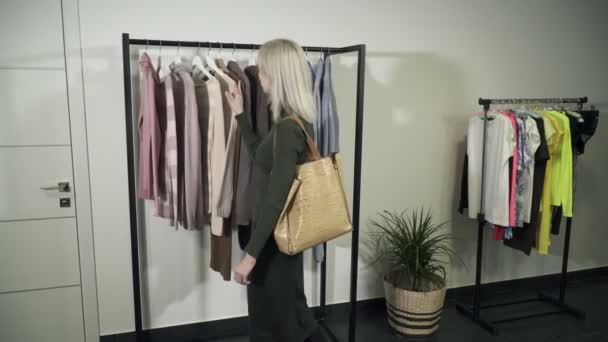 Ung kvinna i boutiquechecks om polo hals passar henne — Stockvideo