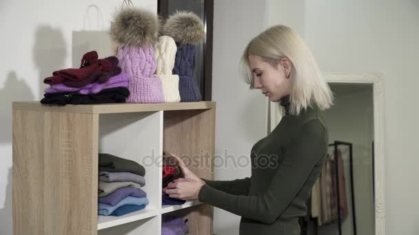 Närbild av ung kvinna i boutique att välja nya clothesfrom hyllorna — Stockvideo