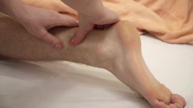 Masör bir adam için closeup bacak masaj yapıyor