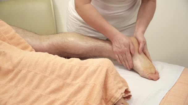 Masajista está haciendo masaje de piernas para un hombre primer plano — Vídeos de Stock