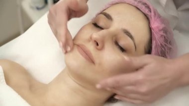 Şevval Özçelik Güzellik maskesi anti-aging kadının yüzüne uyguluyor