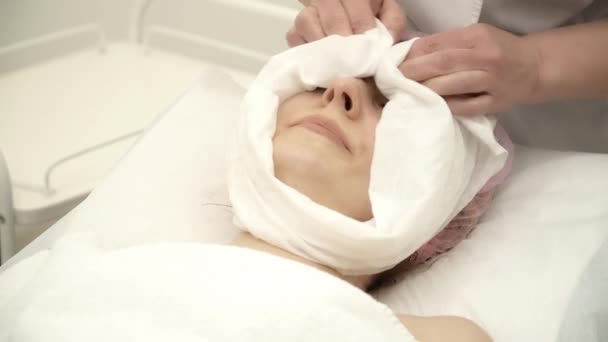 Beautician is clearing a facial anti-aging mask — Stock Video