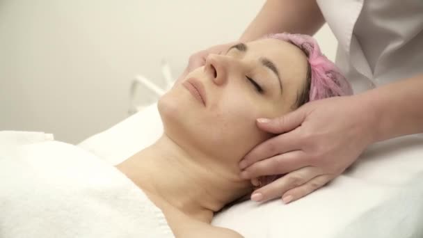 Beautician is making face massage for a woman — Stock Video