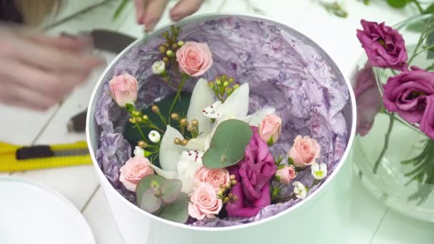 Floristería añadiendo una rosa al ramo en la caja — Vídeo de stock