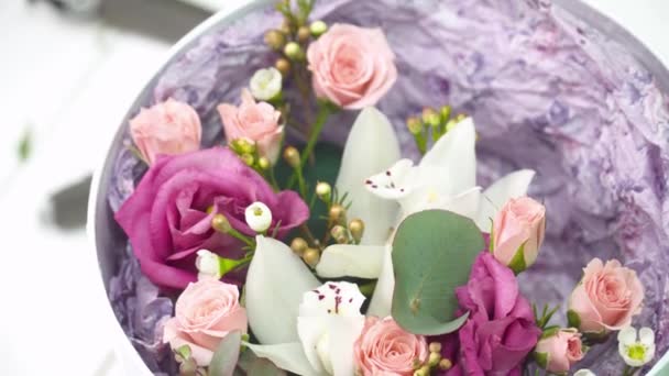 Florista agregando una orquídea al ramo en la caja — Vídeos de Stock