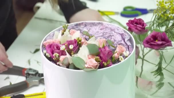 Флорист заполняет коробку розами в цветочном бутике — стоковое видео
