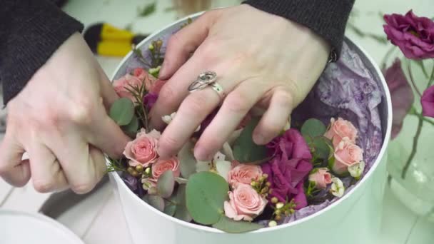 Флорист заповнює коробку трояндами у квітковому бутіку крупним планом — стокове відео