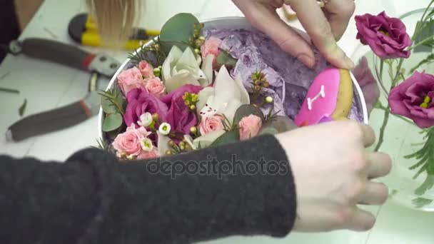 Bloemist een peperkoek in de vorm van hart toevoegen aan het boeket — Stockvideo