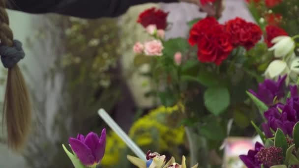 Флорист добавляет розы в цветочную коробку — стоковое видео