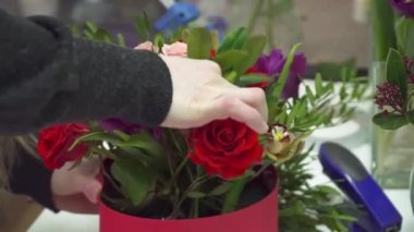 Çiçekçi kutusunda güzel buket üzerinde çalışıyor