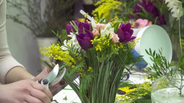 Floristería está cortando las hojas extrañas del ramo — Vídeo de stock