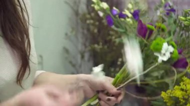 Çiçekçi onun elleri closeup buket yapıyor