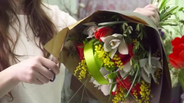Floristería envolviendo el ramo en el papel de regalo de flores — Vídeo de stock