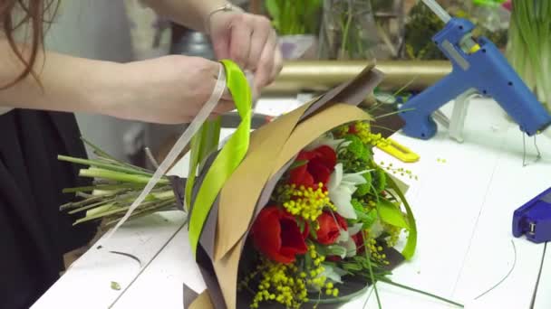 Florarie adaugand panglici la buchet — Videoclip de stoc
