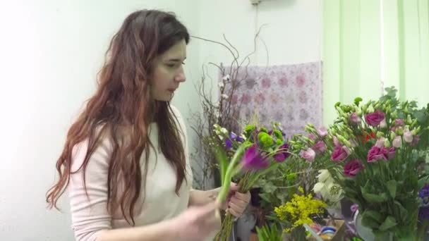 Kwiaciarnia jest Dokonywanie bukiet w jej ręce — Wideo stockowe