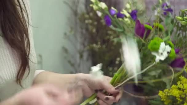 Ανθοκόμος κάνει ανθοδέσμη σε closeup της χέρια — Αρχείο Βίντεο