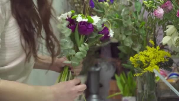 Floristería añadiendo algunas flores al primer ramo — Vídeo de stock