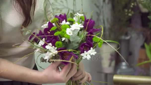 Bloemist sommige bloemen toe te voegen aan het boeket in de bloemenwinkel — Stockvideo