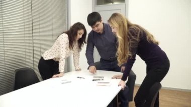 Office ekibi fikirleri tartışmak masa etrafında toplanır