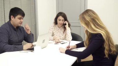 Adam bir dizüstü bilgisayar kullanarak, kadın ofiste toplantı telefonda talkinng