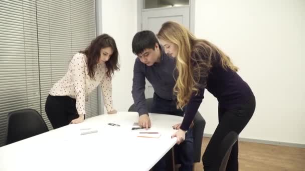 Equipe do escritório está reunida em torno da mesa discutindo o diagrama — Vídeo de Stock