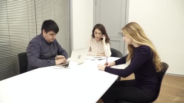 Ο άνθρωπος χρησιμοποιώντας ένα φορητό υπολογιστή, η γυναίκα είναι talkinng στο τηλέφωνο για τη συνάντηση — Αρχείο Βίντεο