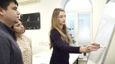 Beyaz tahta ofiste çevresinde toplanan işçilerin takım