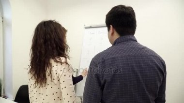 Beyaz tahta fikirleri tartışmak ofiste çevresinde toplanan işçilerin takım