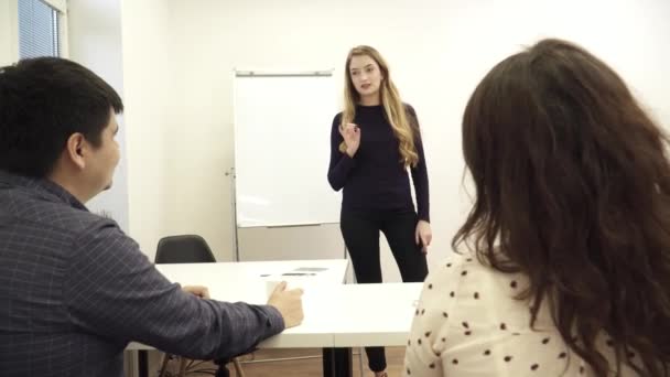 Mujer rubia joven está dando el discurso en la oficina — Vídeos de Stock