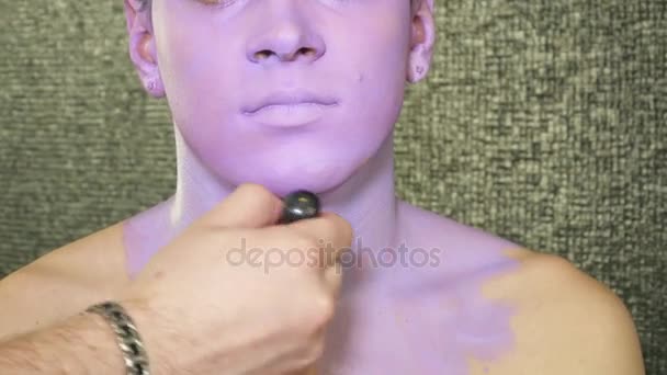 Καλλιτέχνης μακιγιάζ καλύπτει νέοι επανδρώνει τους ώμους με ένα ιώδες χρώμα — Αρχείο Βίντεο