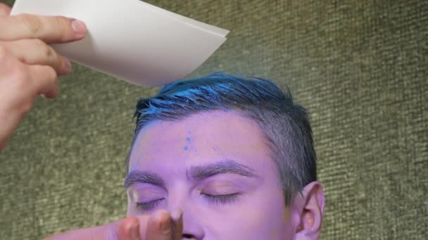 Maquillaje artista sopla los destellos a los hombres de pelo de cerca — Vídeo de stock
