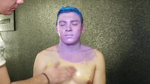 Body art artist pinte giovani il corpo dell'uomo con vernice viola — Video Stock