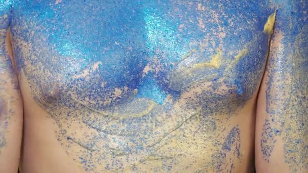 Body-Art-Künstler bedeckt den Körper des jungen Mannes mit blauen Funkeln — Stockvideo