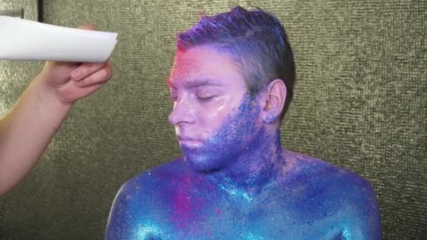 Makeup artist is covering mans hair with pink powder — Stock Video