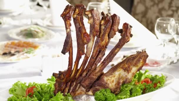 Вкусные жареные ребрышки на столе в ресторане — стоковое видео