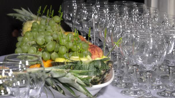 Свежие фрукты рядом с пустыми стаканами — стоковое видео