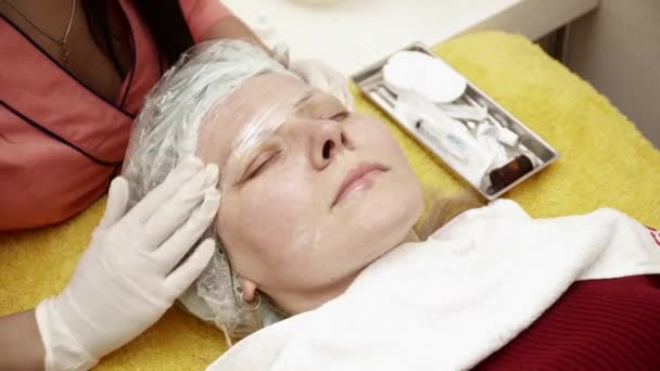Косметолог готує жінку до терапії в салоні крупним планом — стокове відео