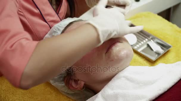 Schoonheidsspecialiste dekking womans gezicht met gel na de anti veroudering procedure closeup — Stockvideo