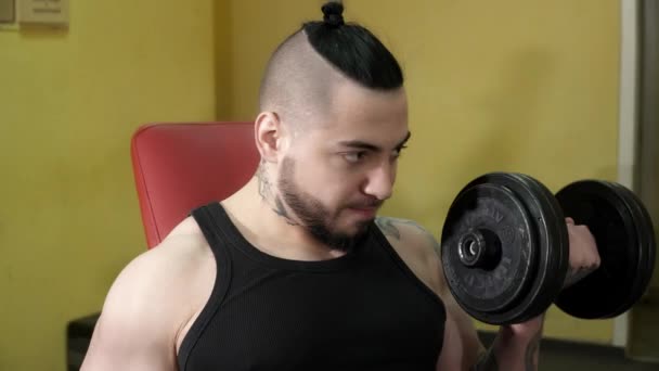 Young man is training with the bar bells in the gym — Stock Video