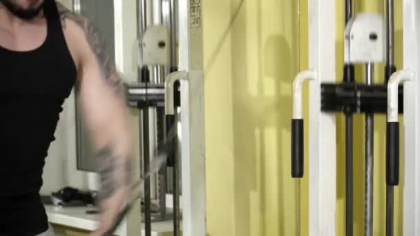 Young man with tatoos is making exercises for his arms in the gym — Stock Video