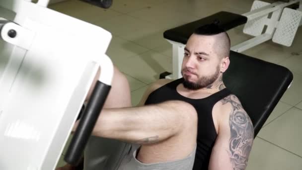 Joven haciendo ejercicios en la prensa de piernas en el primer plano del gimnasio — Vídeos de Stock