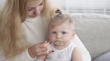 Genç anne onun şirin küçük bebek çocuk besleme