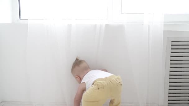 Смешной маленький мальчик играет с занавесками, крупным планом — стоковое видео