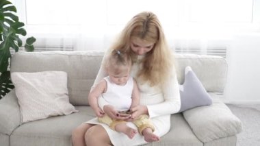 Bir şey küçük oğlu smartphone üzerinde gösterilen genç güzel anne