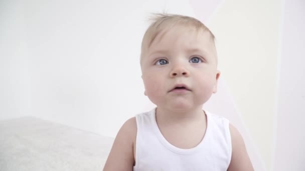 Pequeno menino bonito olhando para a câmera e brincando com ele — Vídeo de Stock