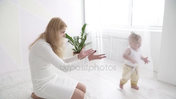 Young mom watching her small baby boy running in the room — Stock Video